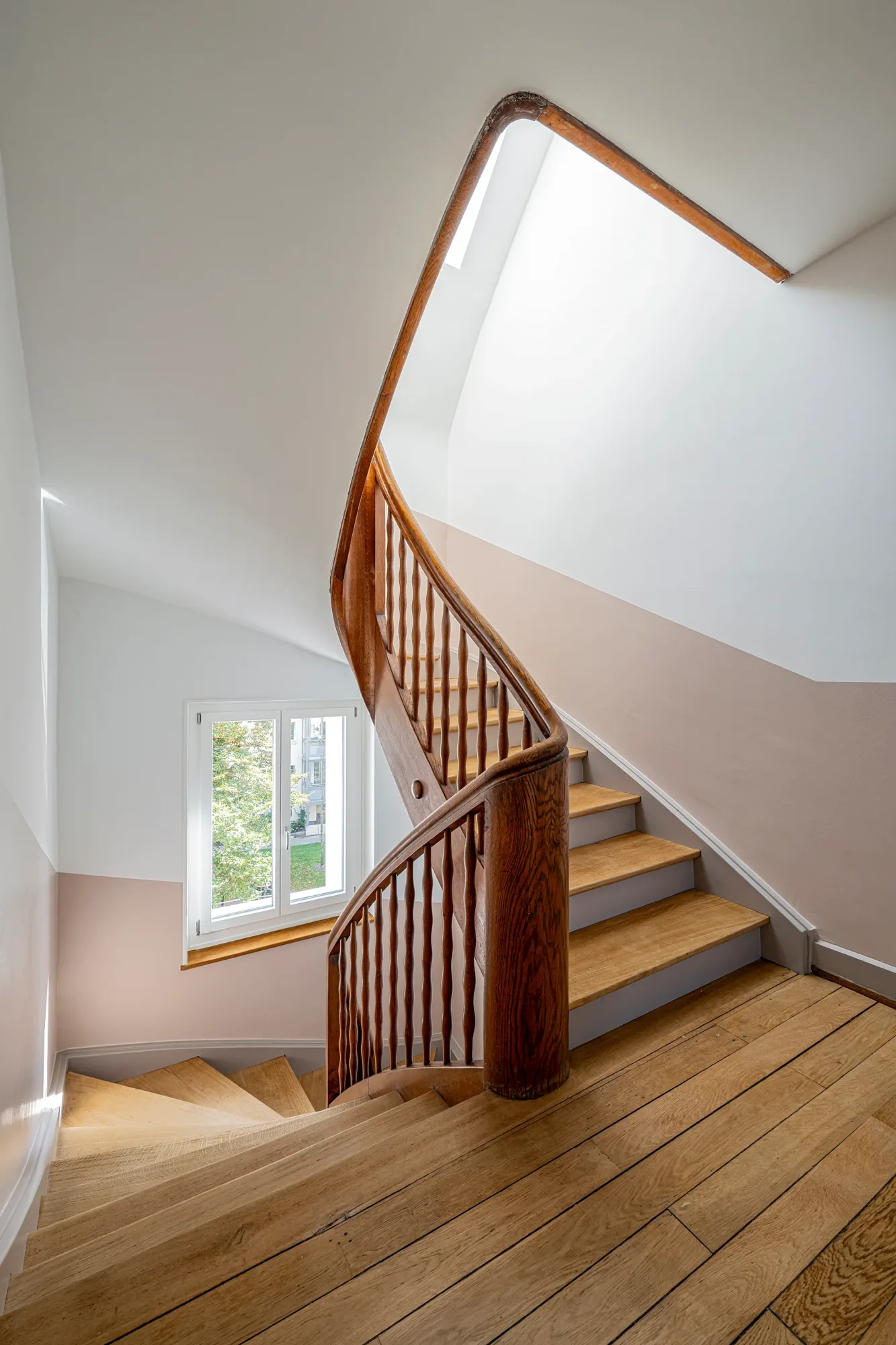 Die alte Holztreppe mit ihrem geschwungenen Geländer bleibt als prägendes Element des Treppenhauses erhalten.